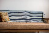 Vintage Indigo Stripe Throw draped over a sofa back, showcasing its hand-woven indigo blue and light stripes.