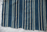 Vintage African indigo textile featuring hand-woven deep blue and off-white vertical stripes.