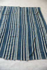 Vintage African indigo textile with unique hand-dyed blue and cream striped texture.