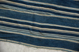 Close-up of vintage African indigo textile, hand woven with variegated blue and cream stripes.