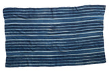 Vintage African indigo textile throw, hand woven with varying blue horizontal stripes.