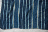 Collectible vintage African indigo textile detail: varying blue vertical stripes and textured handwoven cotton.