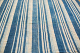 Textured indigo blue and natural cream striped textile with hand woven joined strips.