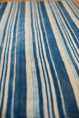 Close-up of textured vintage hand-woven indigo blue and off-white striped textile.