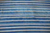 Close-up of collectible hand-woven indigo blue striped textile, showing natural texture variations.