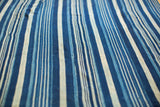 Visible hand-woven texture on a varied indigo blue and cream striped textile.
