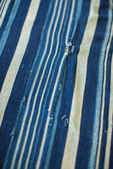 Handwoven indigo blue textile with variegated stripes and characteristic vintage texture.
