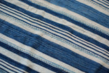 Detail of hand-woven indigo blue and off-white striped collectible cotton textile.