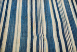 Close view of the collectible indigo striped textile, showing handwoven texture and subtle character.