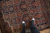 Overhead view of an antique Malayer rug's rich texture and bold geometric tribal design.