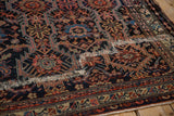 A professionally secured mend on an antique Malayer rug's bold geometric field.