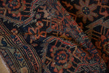Rich hand-knotted pile of a folded antique Malayer with navy and jewel-toned tribal motifs.