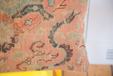 Storied hand-knotted texture and time-softened blue and pink motifs on the antique pillow.