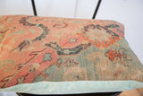 Antique Turkish rug fragment pillow edge, faded peach and blue, meeting light blue corduroy.