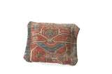 Right corner detail of Heriz fragment pillow, showing worn red and blue geometric pattern.