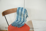 Vintage African indigo textile with varied blue and ivory stripes and fringed edge.