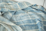 Hand woven vintage African textile, varied blue and ivory stripes, with visible repair stitching.