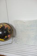 Vintage African indigo pillow, displaying sun-faded blue hues and textured surface.