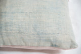 Faded blue vintage African Indigo pillow textile detail with visible horizontal stitches.