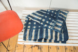 Unique ivory dot and stripe patterns on a folded vintage African indigo textile.