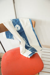 Vintage African indigo textile with unique circular motifs on blue and ivory cotton.