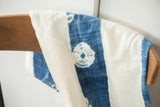 Collectible hand woven African indigo textile with ivory stripes and circular patterns.