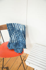 Hand-woven vintage African textile throw displaying indigo and ivory geometric patterns.