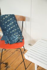 Collectible vintage African indigo textile with ivory eye patterns and raw edges.