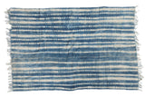 Hand-woven African indigo textile throw featuring unique ivory and denim blue resist stripes.