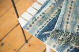 Collectible African textile corner with hand-woven ivory and indigo pattern and tassels.