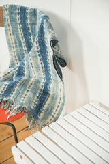 Hand-woven African textile throw corner, ivory and blue pattern with short fringe.
