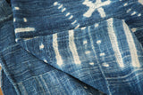 Handwoven denim blue and ivory African indigo textile with unique patterned motifs.