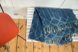 Vintage African indigo textile with hand-woven denim blue diamond pattern and tassels.