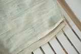 Layered hand-woven vintage African cotton textile, ivory with subtle powder blue indigo dye.