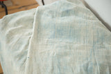 Supple hand-woven ivory and powder blue indigo textile, showcasing its vintage character.