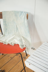 Supple hand woven ivory and powder blue African indigo textile with short tassels.