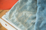 Close-up of a collectible hand-woven African indigo textile, showing varied powder blue tones.