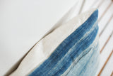 Reclaimed vintage indigo pillow texture showing sun-faded blue and ivory linen.