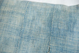 Sun-faded light blue indigo pillow with woven texture and vertical stitching.