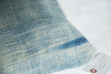Vintage light blue indigo pillow fabric, sun-faded texture, visible seam, and dark stripe.