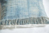 Reclaimed vintage African Indigo pillow with sun-faded blue textile and frayed fringes.
