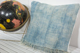Sun-faded light blue vintage indigo pillow showcasing textile texture and vertical stitching.