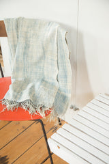 Hand woven vintage African textile throw featuring subtle light blue bands and short tassels.