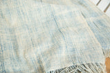 Supple hand-woven blue cotton textile showing textured panels and fringe.