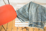Hand-woven denim blue African textile with visible vertical seams and frayed edge.