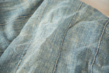 Intricate hand-woven denim blue cotton texture of a vintage African textile throw.