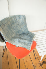 Detailed view of collectible denim blue African textile with hand woven texture and frayed edge.