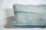 Sun-faded light blue vintage indigo textile and canvas back seam on pillow.