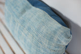 Close-up of sun-faded light blue vintage African Indigo textile texture and seam.
