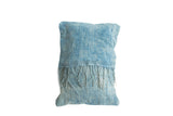 Close-up of the reclaimed vintage African indigo pillow's sun-faded texture and long tassels.